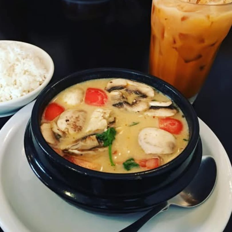 Creamy Tom Kha Gai soup with mushrooms and tomatoes, served with rice and iced Thai tea.